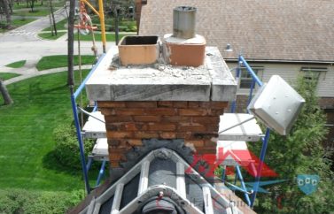A chimney in the process of getting leaks repaired, with a special ladder bent over the roof.