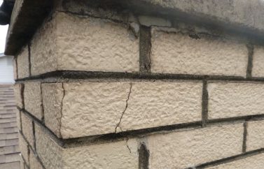 Up close view of a neutral-colored brick chimney.